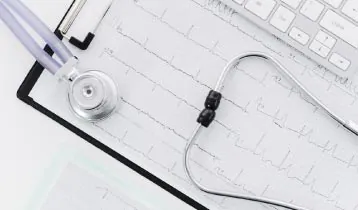 Estetoscópio sobre o traçado impresso de um eletrocardiograma