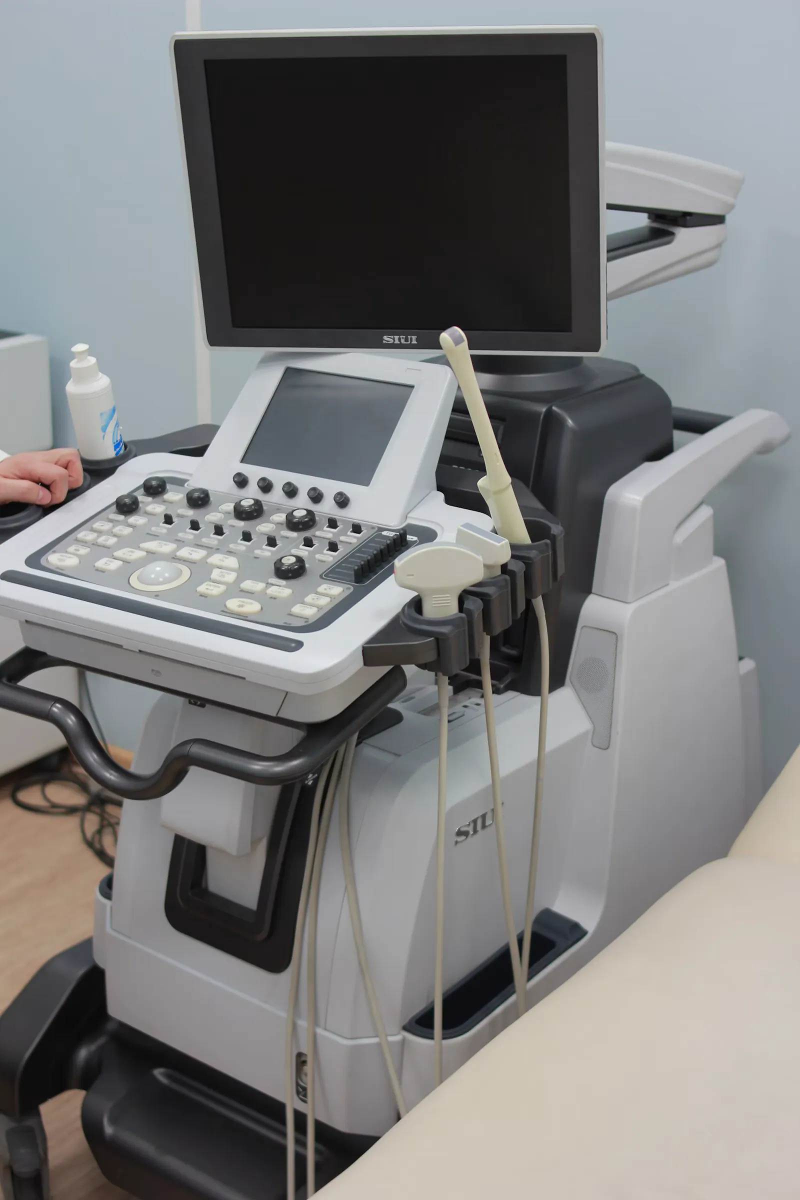 Aparelho de ecocardiograma com monitor e transdutores na sala de exame
