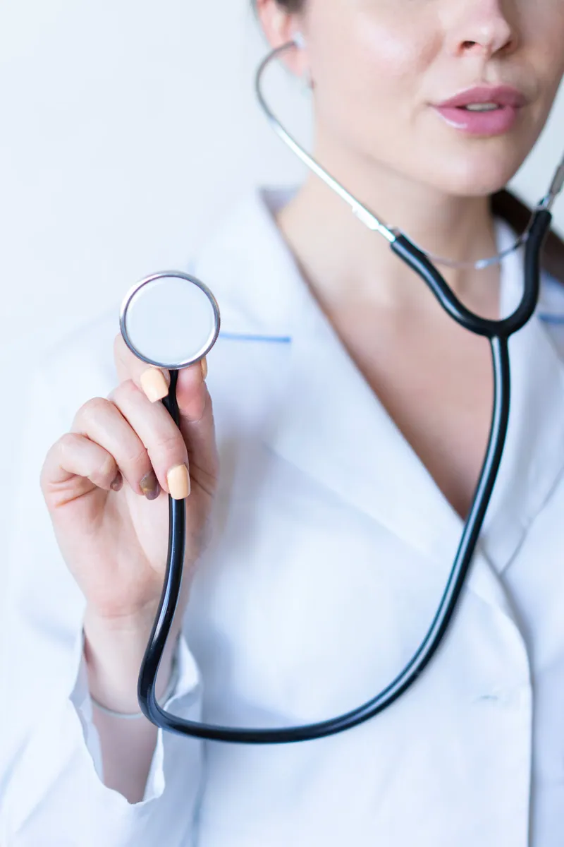 Médica segurando um estetoscópio para exame cardíaco, contexto do monitoramento contínuo do Holter 24 horas