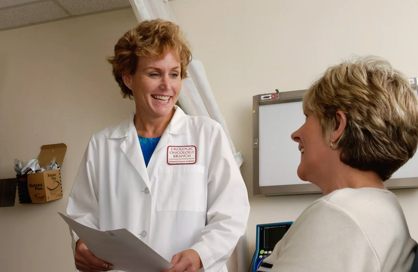 Médica sorridente conversando com paciente durante consulta