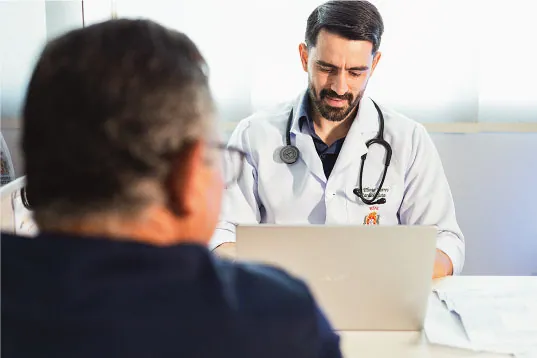 Dr. Plínio Torres atendendo um paciente no consultório